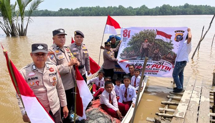Sambangi Wilayah Terluar, Polsek Reteh Bagikan Bendera dan Tanam Mangrove Bersama